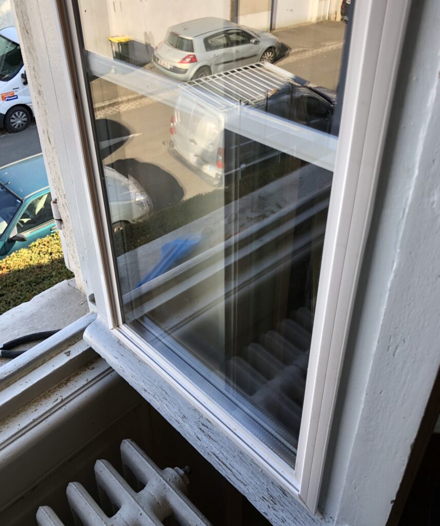 Vitrage de rénovation en double vitrage avec un cadre pvc, installé sur une fenêtre en bois