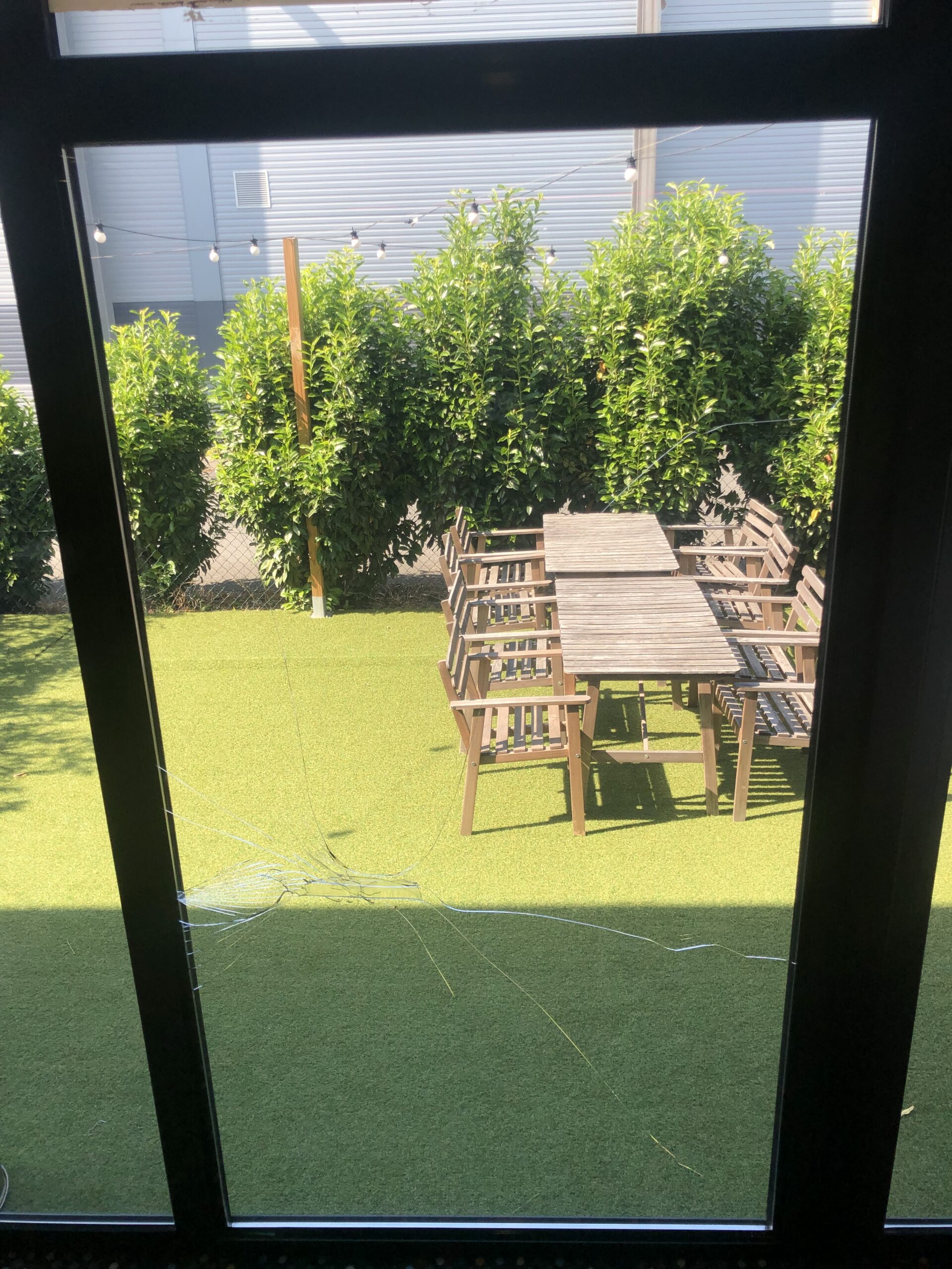 Vitrine fissurée donnant sur une terrasse exterieure ensoleillée