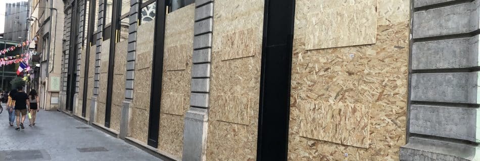 Barricades en bois sur plusieurs vitrines de magasins